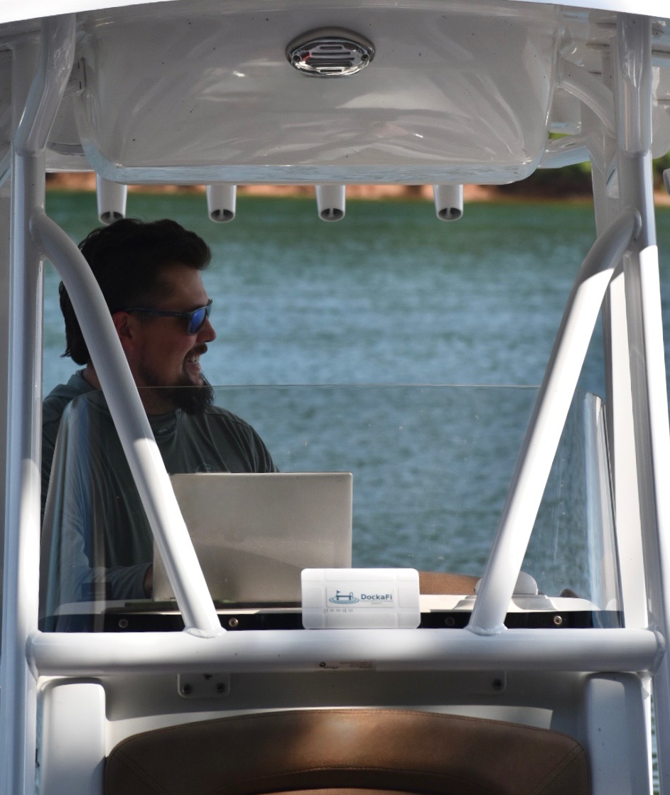 DockaFi mounted on center console boat with user on laptop